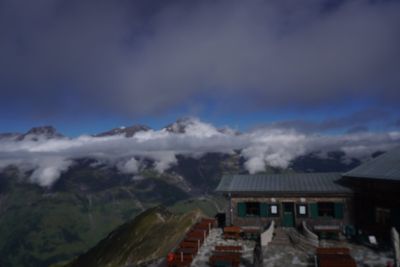 Mountain hut terrace looking over peaks poking through cloud