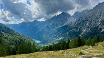 Turquoise alpine lake in a forested valley south of the Glockner