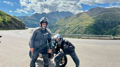 Two riders on the Glockner road with peaks behind them