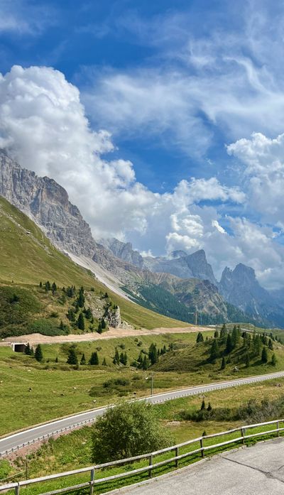 Winding pass road, rifugio corner, and clouds on the peaks