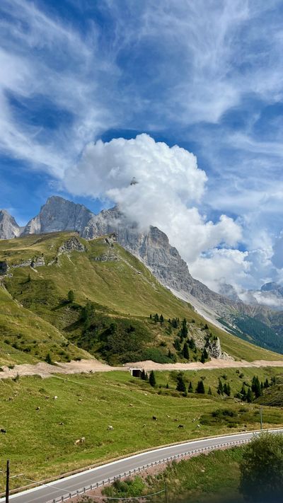 Alpine pasture, cows, and a peak catching a cloud south of Arabba