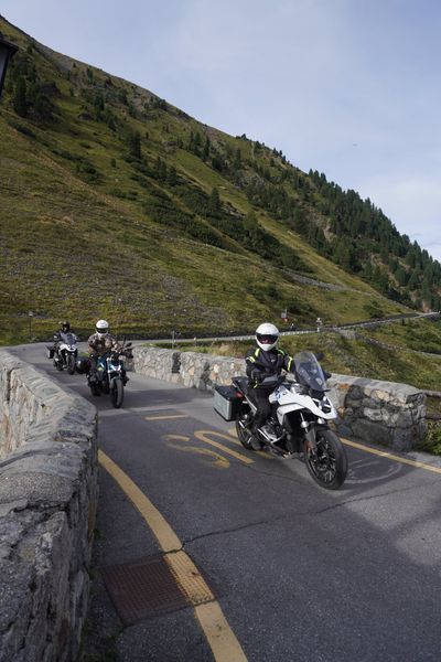 Touring bikes working a stone-walled curve on the pass