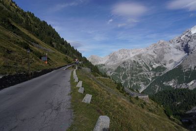 High alpine road curving toward a rock wall