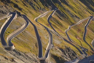 Stacked Stelvio hairpins in long morning shadow