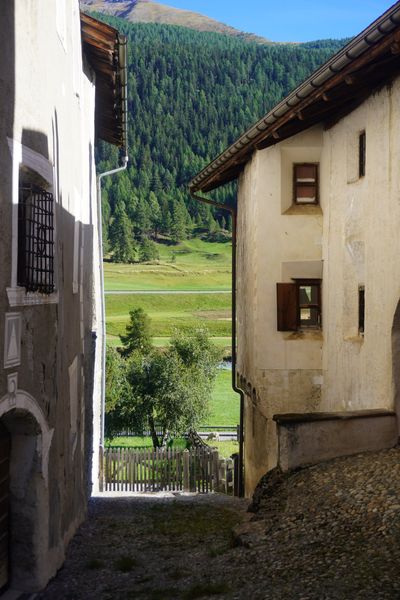 Narrow alley framing a sunlit mountain