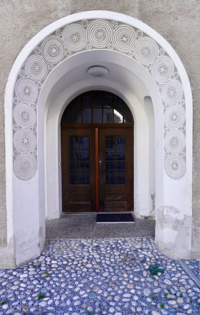 Sgraffito circles and stars around an arched doorway