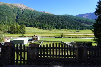Wooden fence opening onto a meadow and mountains