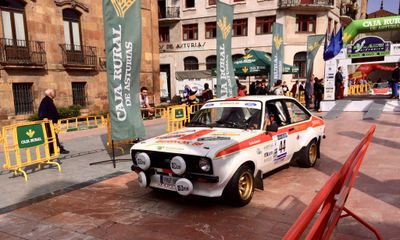 Crowd gathering around classic rally cars